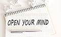 Text on notepad OPEN YOUR MIND on white background. Business Concept Royalty Free Stock Photo