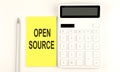 Text OPEN SOURCE on the yellow sticker, next to pen and calculator