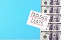 Text paid sick leave and money on a blue background