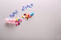 Text PANIC ATTACK and pills on white background, top view