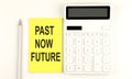 Text PAST NOW FUTURE on yellow sticker, next to pen and calculator Royalty Free Stock Photo