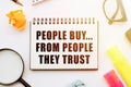 Text - People Buy From People They Trust in notebook on white table with office tools Royalty Free Stock Photo