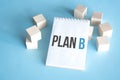 Text PLAN B on white notepad with cube block, stock concept
