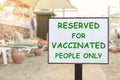 Text plate RESERVED FOR VACCINATED PEOPLE ONLY at luxury hotel sea beach resort area empty loungers on summer day. New Royalty Free Stock Photo