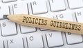 Text POLICIES GUIDELINES on wooden pencil on white keyboard. Business concept