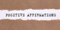 The text POSITIVE AFFIRMATIONS appearing behind torn paper. business