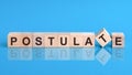 The text POSTULATE is written on the cubes in black letters, the cubes are located on a blue glass surface Royalty Free Stock Photo