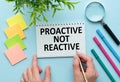 Text Proactive not reactive on white paper book on table, business concept