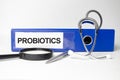 the text probiotics text on a notebook on the doctor's desk next to it is a stethoscope and tablets