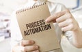 Text Process Automation on brown paper notepad in businessman hands in office. Business concept Royalty Free Stock Photo