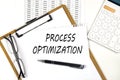 Text PROCESS OPTIMIZATION on the white paper on clipboard with chart and calculator Royalty Free Stock Photo