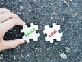 Text profit loss written on jigsaw puzzle with hand against asphalt background. Royalty Free Stock Photo