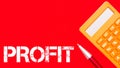 Text PROFIT written on paper notes with pen and calculator isolated on red background.