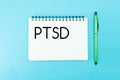 Text PTSD of Posttraumatic stress disorder on paper on blue