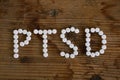 text Ptsd  writing with pills on wooden table . Concept meaning Post Traumatic Stress Disorder Mental Illness Trauma Fear Royalty Free Stock Photo