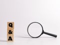 Text Q AND A on wooden cubes with magnifying glass isolated on white background. Royalty Free Stock Photo