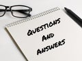 Text QUESTIONS AND ANSWERS on notebook with marker pen and eye glasses. Royalty Free Stock Photo