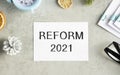 The text Reform 2021 on office desk with alarm