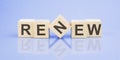 text RENEW on wooden cubes. bright blue surface