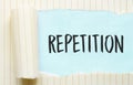 The text REPETITION appearing behind torn white paper Royalty Free Stock Photo