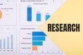 Text RESEARCH written In a yellow triangle on a white background with financial charts and graphs