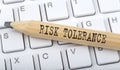Text RISK TOLERANCE on wooden pencil on white keyboard. Business concept