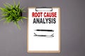 Text ROOT CAUSE ANALYSIS on brown clipboard on the grey background. Business concept