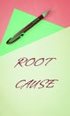 The text Root Cause on paper background with pen