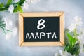 Text in Russian: March 8. Black chalkboard and white flowers. International Women`s Day. Royalty Free Stock Photo