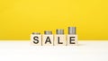 text sale on wooden cubes on yellow background Royalty Free Stock Photo