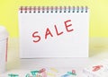 The text sale is written on a sheet of a notebook, as a reminder of the importance of not missing the sale, discounts Royalty Free Stock Photo