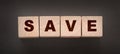 Text SAVE on a wooden cube blocks on black background. Money saving concept