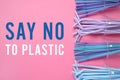 Text SAY NO TO PLASTIC and disposable cups with straws on pink background, flat lay Royalty Free Stock Photo