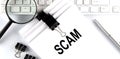 Text scam on paper on the keyboard with office tools Royalty Free Stock Photo