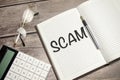 Text scam on paper on the keyboard with office tools Royalty Free Stock Photo
