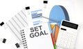 Text SET GOAL on a notebook on the diagram and charts with calculator and pen Royalty Free Stock Photo