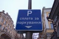 Text on sign: Pay for parking here. Rectangular blue plate with white text. Concept of parking in big city Royalty Free Stock Photo