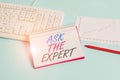 Text sign showing Ask The Expert. Conceptual photo Looking for professional advice Request Help Support Paper blue desk