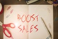 Text sign showing Boost Sales. Conceptual photo move sales profit from a lower to a higher place or position Scissors