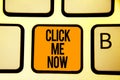 Text sign showing Click Me Now. Conceptual photo Internet helping desk Press the button Online Icon Nertwork Keyboard orange key I Royalty Free Stock Photo