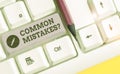 Text sign showing Common Mistakes question. Conceptual photo repeat act or judgement misguided or wrong White pc keyboard with Royalty Free Stock Photo