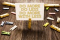 Text sign showing Do More Do Less Do More With Less. Conceptual photo dont work hard work smart be unique Clothespin holding white Royalty Free Stock Photo