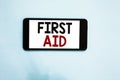 Text sign showing First Aid. Conceptual photo Practise of healing small cuts that no need for medical training Cell phone white sc Royalty Free Stock Photo