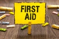 Text sign showing First Aid. Conceptual photo Practise of healing small cuts that no need for medical training Clothespin holding Royalty Free Stock Photo