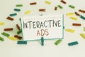 Text sign showing Interactive Ads. Conceptual photo uses interactive media to communicate with consumers Colored clothespin papers