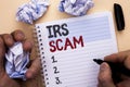 Text sign showing Irs Scam. Conceptual photo Warning Scam Fraud Tax Pishing Spam Money Revenue Alert Scheme written by Man on Note
