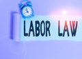 Text sign showing Labor Law. Conceptual photo rules relating to rights and responsibilities of workers Alarm clock and