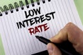 Text sign showing Low Interest Rate. Conceptual photo Manage money wisely pay lesser rates save higher written by Man on Notepad h Royalty Free Stock Photo