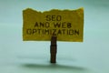 Text sign showing Seo And Web Optimization. Conceptual photo Search Engine Keywording Marketing Strategies Paperclip hold torn yel