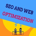 Text sign showing Seo And Web Optimization. Conceptual photo Search Engine Keywording Marketing Strategies Two men sitting behind Royalty Free Stock Photo